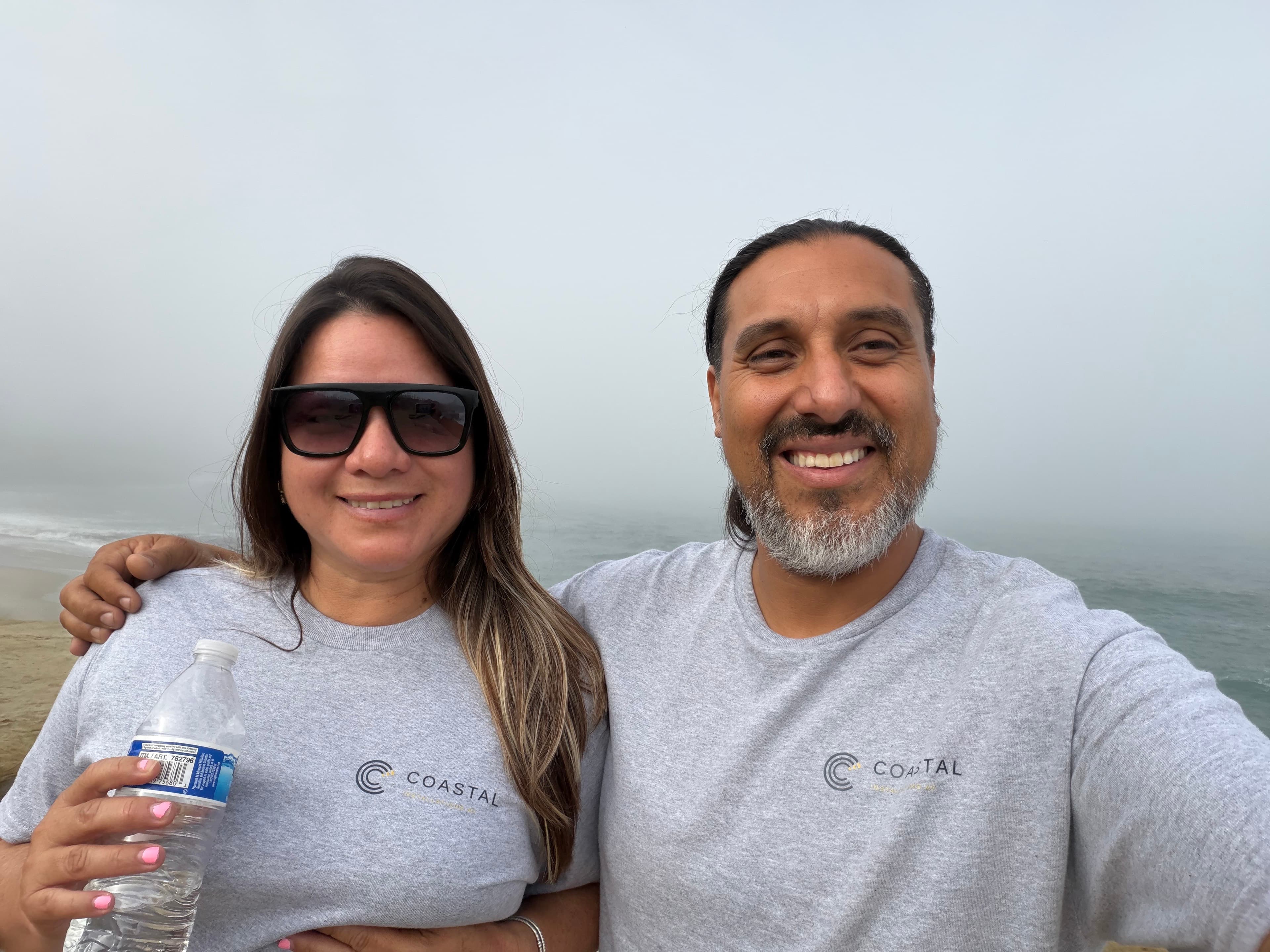Miguel and Barb from Coastal standing together at the San Diego coast.